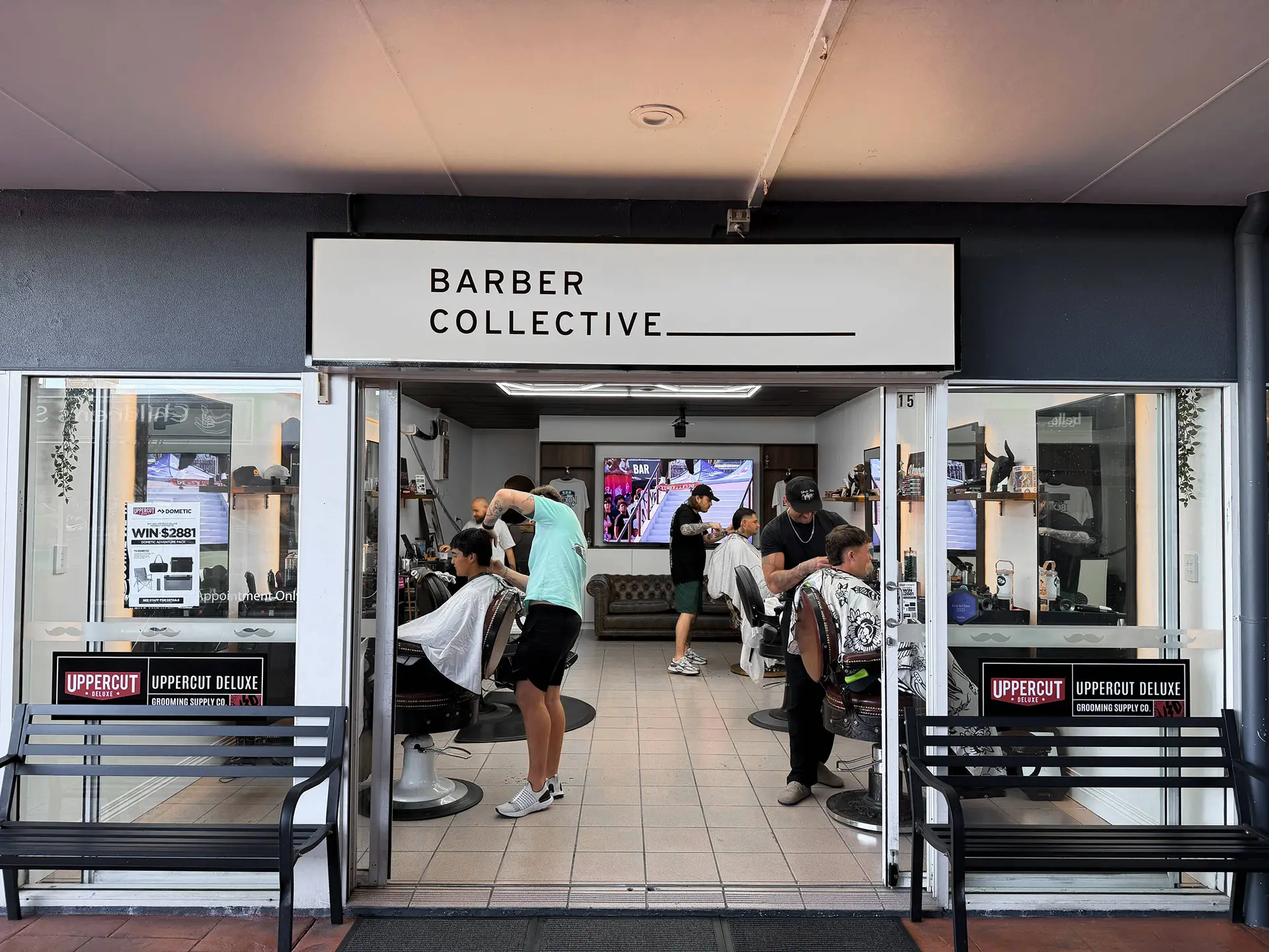 The Barber Collective shopfront on Burnett Street, Buderim, with barbers cutting inside